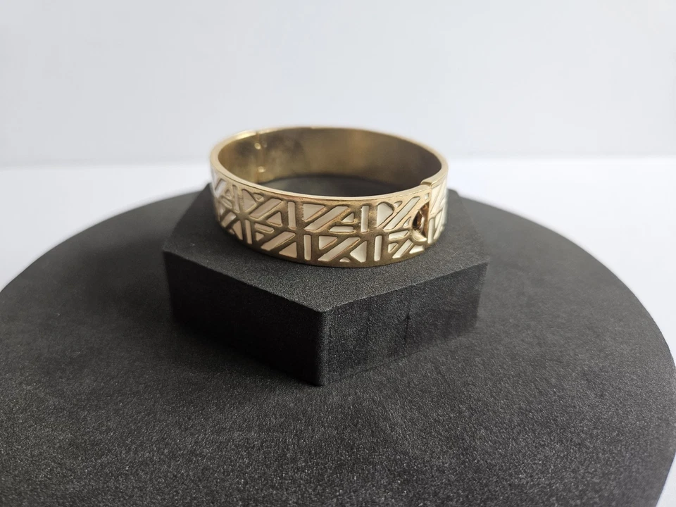 Pulsera con incrustaciones de esmalte tono dorado hermosos pequeños diseños geométricos color crema Foto 2 de 4