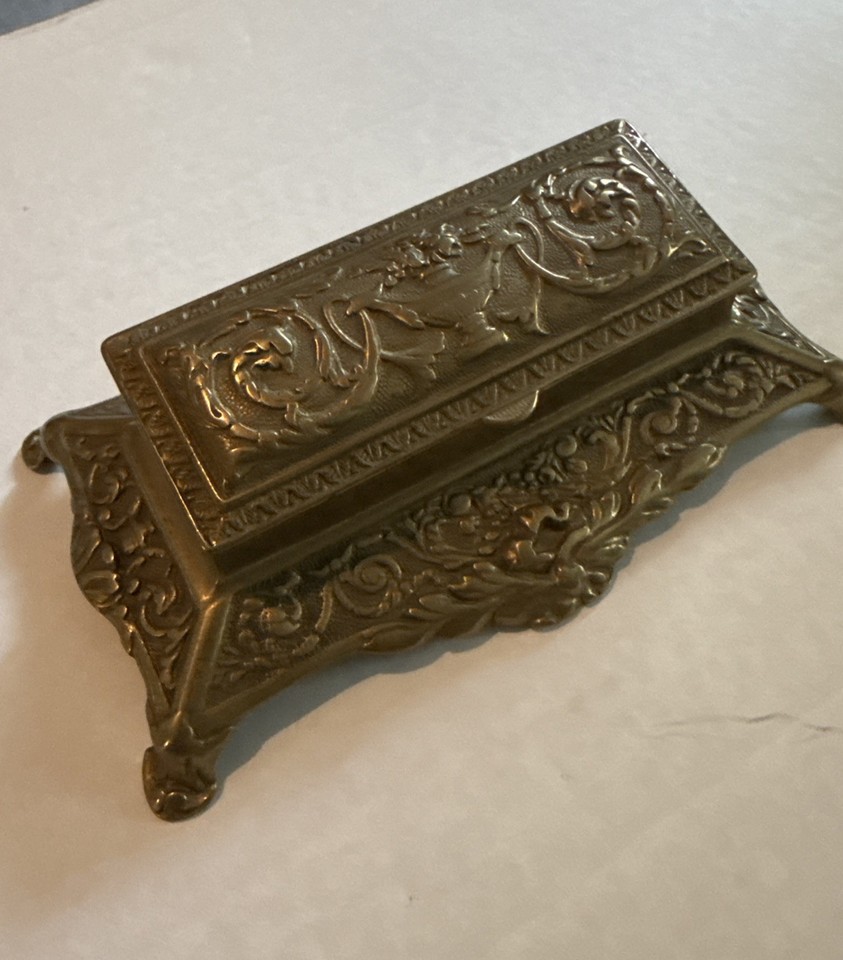 An Art Nouveau brass stamp box with sculptural detailing — a genuinely rare desk artifact in the age of email.