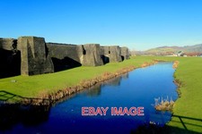 PHOTO  CAERPHILLY CASTLE . THE EAST WALL AND MOAT WITH A BACKGROUND OF THE HILLS
