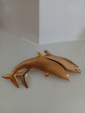 Goldtones dolphins satin & shiny brooch features a double leaping design of...