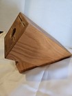 Cutco solid honey oak wood knife storage block with triangular front, featuring two black slots and a circular cutout handle.