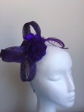 Cute purple loop fascinator with flower, netting and feathers on headband.