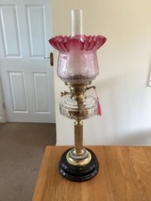 A Sliced Glass Duplex Oil Lamp With A Cranberry shade.