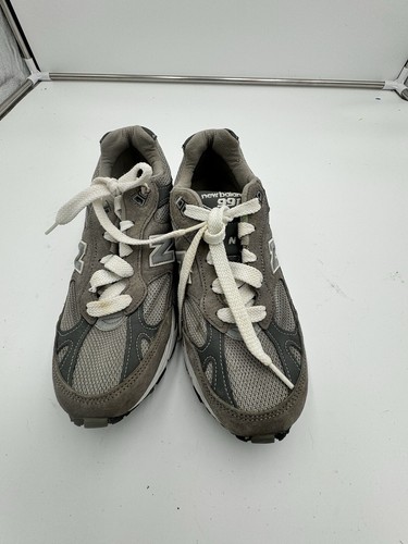 Grey New Balance 991 dark grey size 7 with white laces, suede overlays, and mesh uppers on a white background.