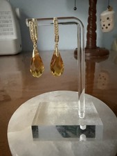 Gold tone dangle earrings with faceted orange teardrop stones