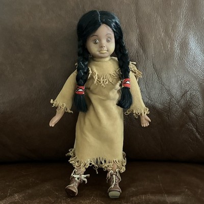 Puppe im indianischen Stil mit geflochtenen schwarzen Haaren und hellbraunem Fransenkleid
