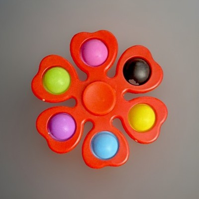 flower-shaped pop fidget spinner, a sensory toy that combines spinning & popping