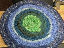 Handcrafted fabric coiled rag rug in shades of green blue 24" round