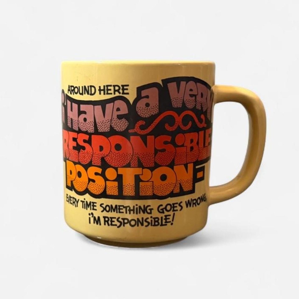 An actual 1984 novelty mug with a deadpan office-humor motto — the kind of thing you genuinely stumble upon and can't leave behind.