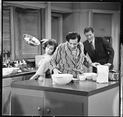Morey Amsterdam cooks breakfast in the kitchen accompanied by Amer- Old Photo