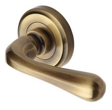 Image of Heritage Brass Door Handle Lever Latch on Round Rose | Charlbury | Sold in pairs