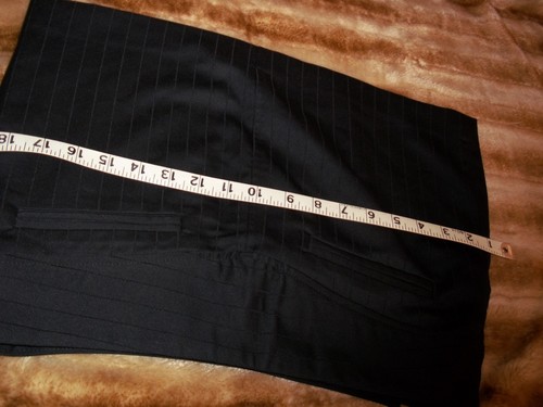 Black mini skirt with vertical pin stripes, white measuring tape, and “MADE IN USA” label at bottom.