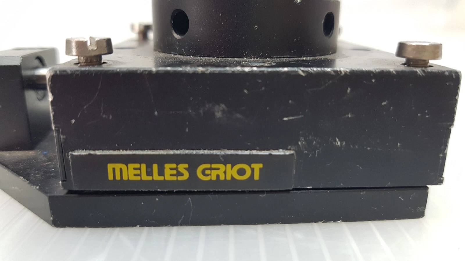 Yellow Melles Griot name plate on the black translation stage