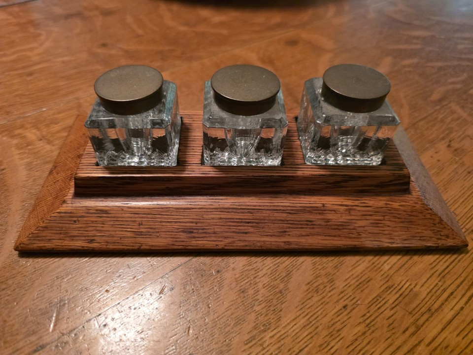 A triple antique oak inkwell stand with hobnail glass wells and brass tops — an absolutely stunning Victorian-era desk centerpiece.