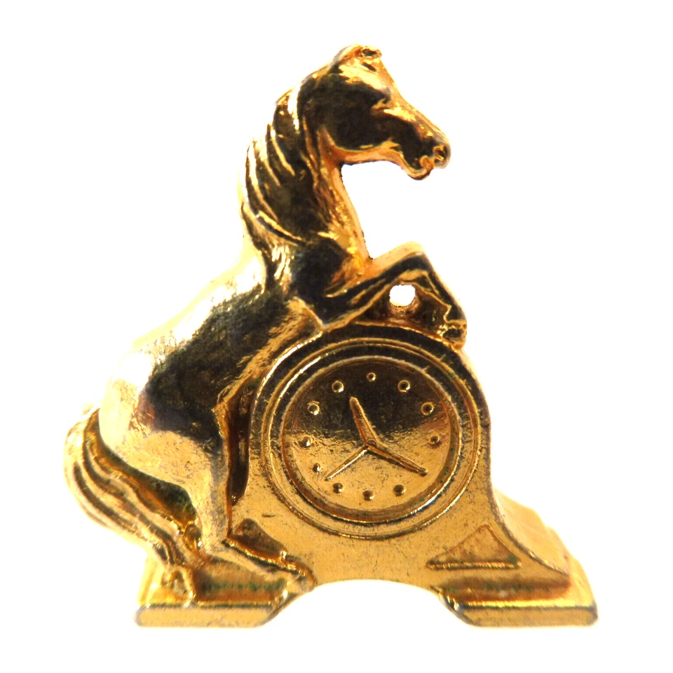 Fève métal doré - UNE PENDULE - Photo 1/1