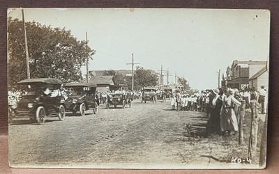 RPPC 1910's Parade Multiple Automobiles Unpaved Main Street Lined With Onlookers