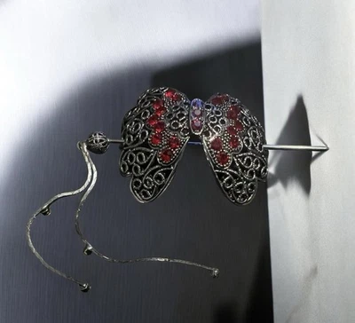 A vintage filigree butterfly hair accessory with red and purple stones. - Image 1 of 3