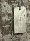 Cream long sleeve dress with green linen tag showing “Chalet et Ceci” text, floral accents, and size “L” label.