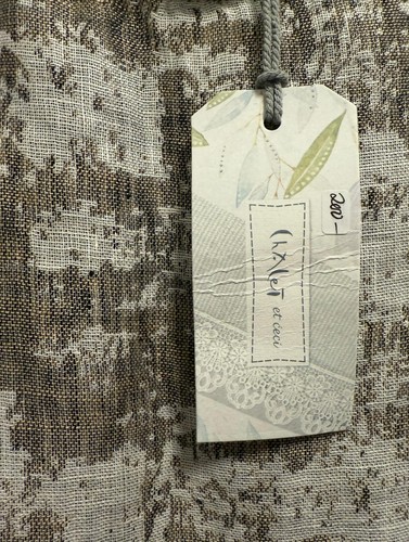 Cream long sleeve dress with green linen tag showing “Chalet et Ceci” text, floral accents, and size “L” label.