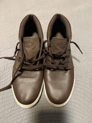 These are brown Lacoste Ampthill leather high-top sneakers with a white sole