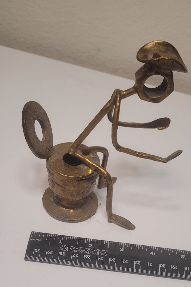 A hand-crafted found-object folk art cowboy sitting on a toilet — this is the kind of unhinged, one-of-a-kind piece that stops guests dead in their tracks.