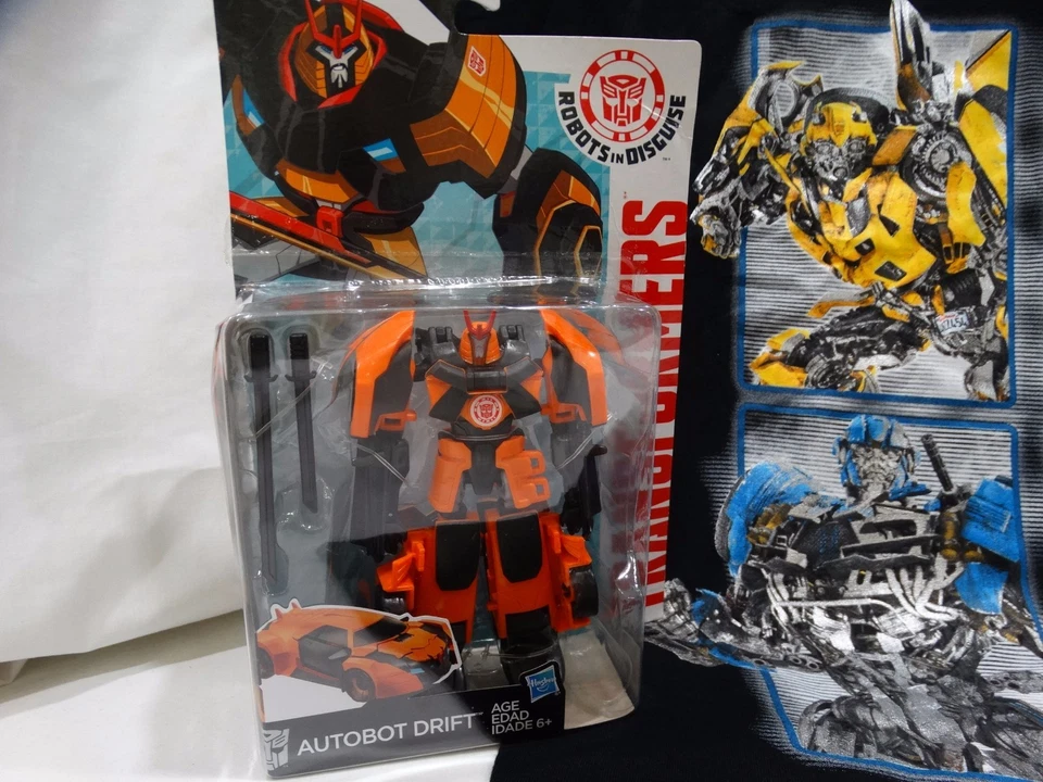 UNIVERSAL STUDIOS TRANSFORMERS SM T-SHIRT, AUTOBOT DRIFT TOY, KEYCHAIN, & LANYAR - Image 2 of 4