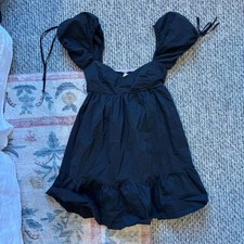 Olivaceous black mini dress with puffy sleeves and tie up straps. Size: S