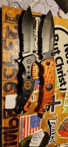 2- ORANGE KNIVES, SKULL, BARBED WIRE, & EMT- EMS BADGE, 2X W/ASSISTED OPENING.