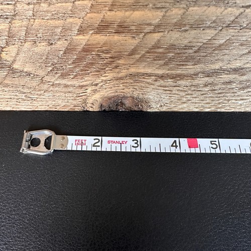 Vintage Stanley 50 foot hand crank tape measure with black and red vertical scale marked in feet and inches, made in USA.