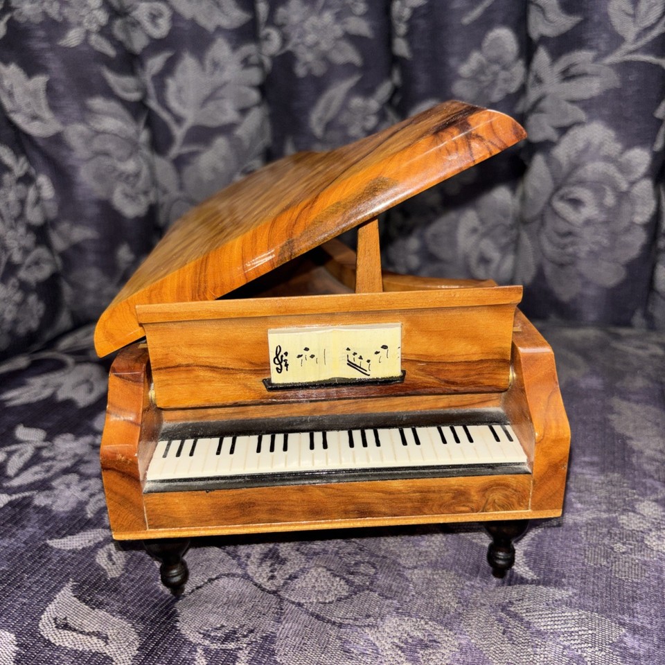 A Reuge-made olive wood piano music box playing 'Fascination' — Reuge is the Swiss gold standard of music boxes and olive wood makes it genuinely beautiful.