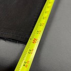 Black faded bootcut jeans with visible yellow measuring tape along the waistband, showing size 33 and 36.