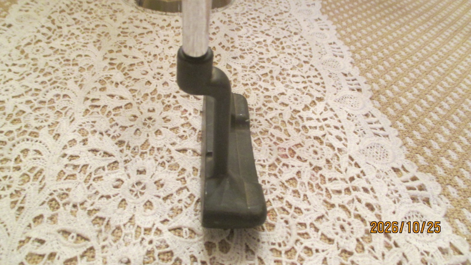 Black vintage PING Anser putter head with silver shaft on beige lace doily, marked “2026/10/25 Made in USA.”
