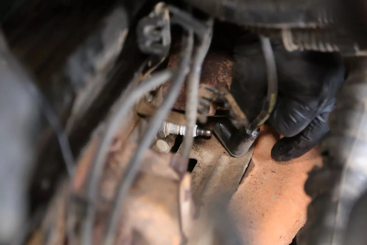 A mechanic connects a new spark plug to the spark plug.