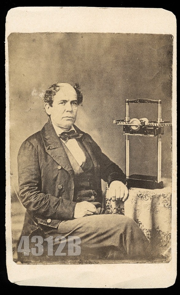 An 1860s albumen portrait of a man proudly posing with a mysterious scientific instrument — a conversation piece that doubles as a window into Victorian scientific culture.