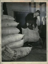 1954 Press Photo Man Empties Bag into Device - neo21479