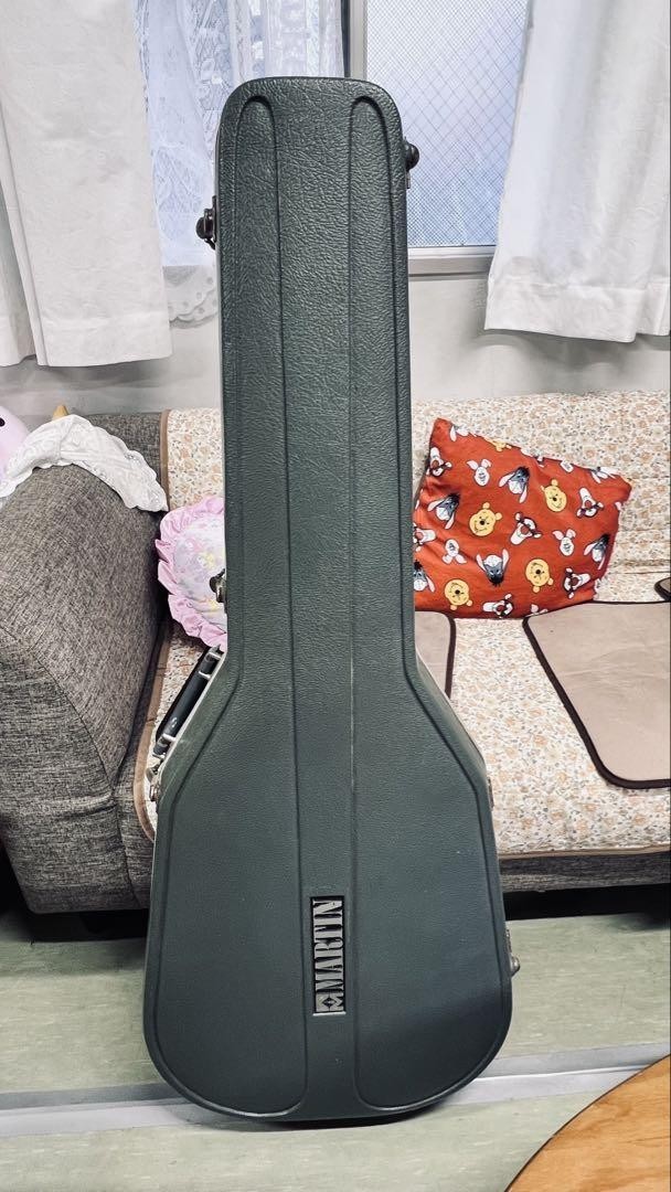 Black Martin D-76 acoustic guitar with hard shell case, silver hardware, and ornate “Martin D-76 Limited Edition” sticker.