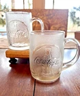 2 vintage frosted glass Coca-Cola mugs with an embossed bottle pattern and logo