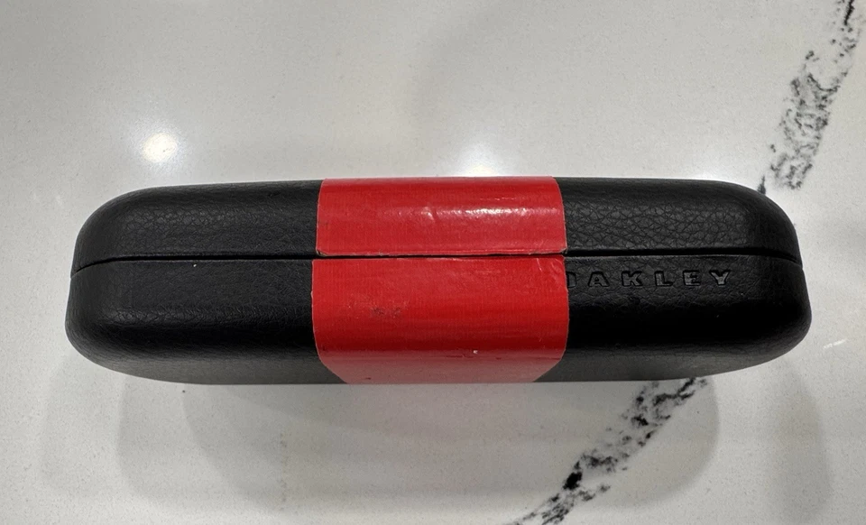 Gafas de sol Oakley negras rígidas estuche con cinta decorativa roja Foto 2 de 4