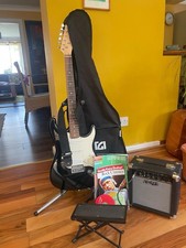 Black Stagg guitar with case, amp, guitar stand, foot stand and guitar strap.