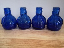 Set Of Four Blue Glass Bottles In Large Man Shape