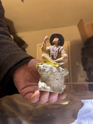 Unmarkierte Indianer sitzend auf einem Felsen Figur 