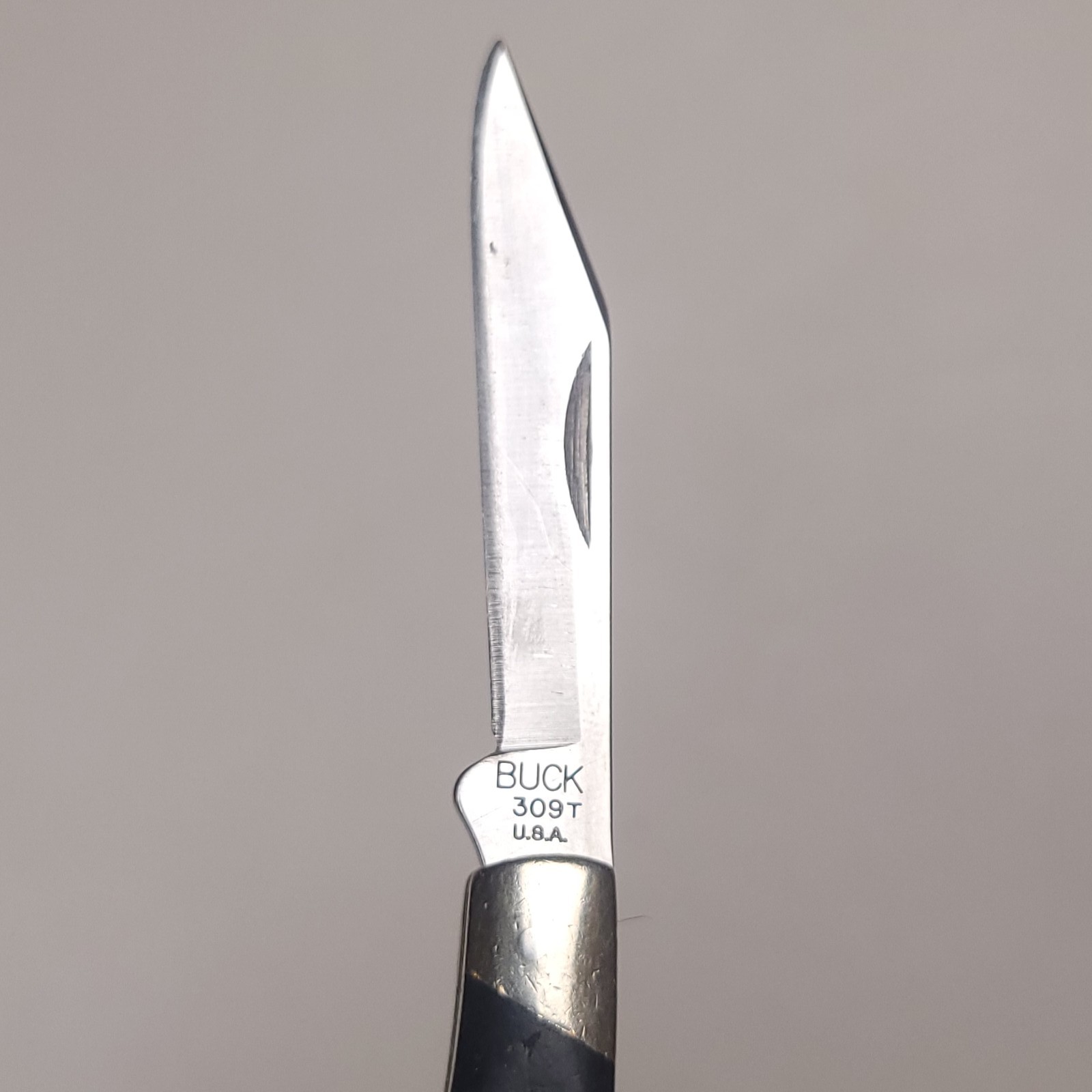 Buck knives 309 T with silver steel blades, black handles, and white “BUCK 309 T.U.A.” engraving on side.