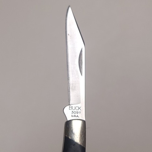 Buck knives 309 T with silver steel blades, black handles, and white “BUCK 309 T.U.A.” engraving on side.