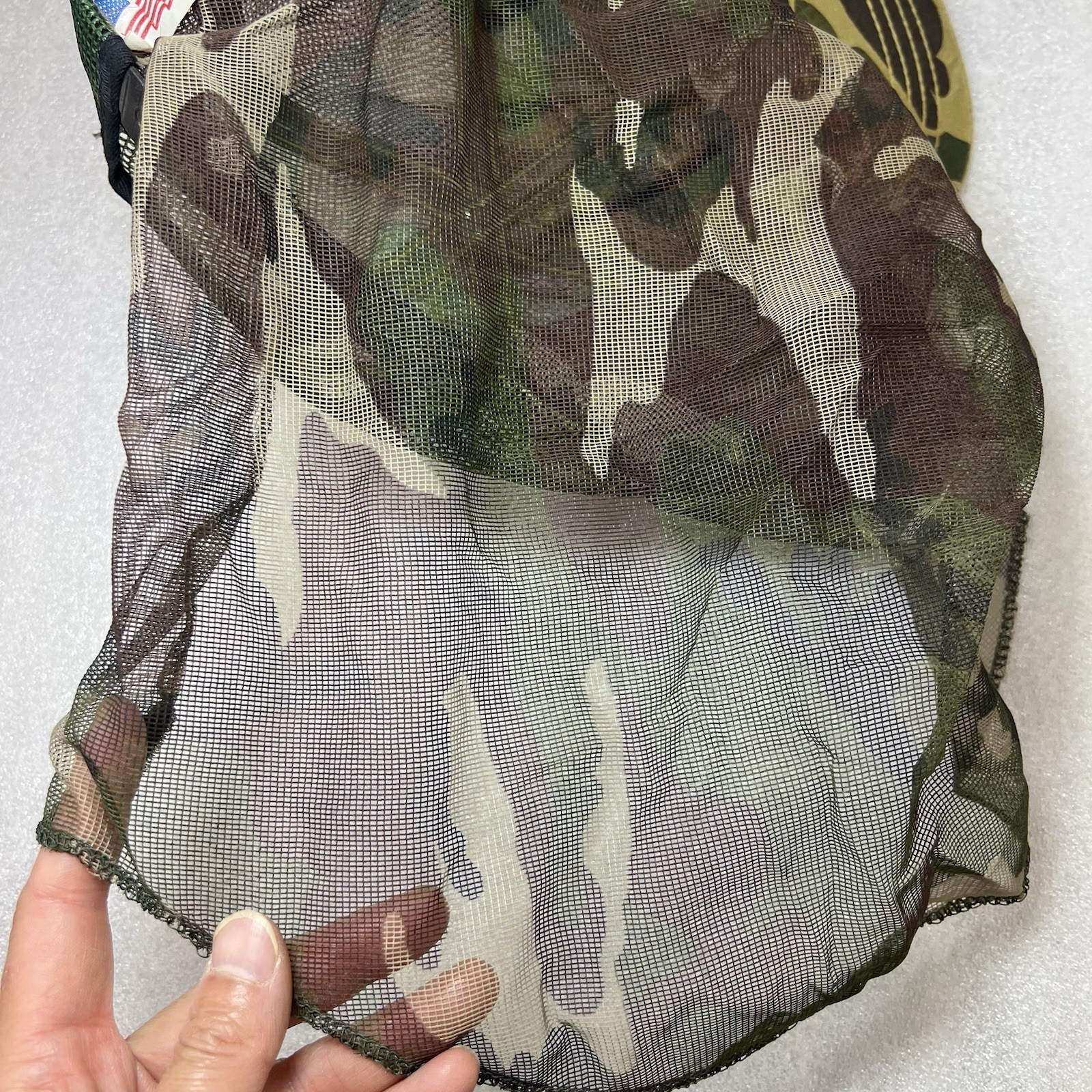 Close-up of Vtg Camo hunting mosquito net with green and brown camouflage pattern and sheer fabric.