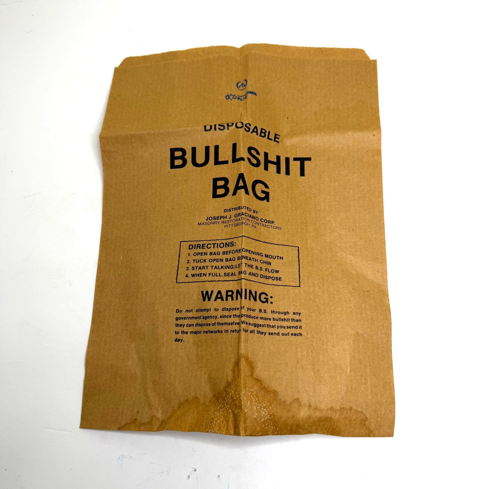 A vintage novelty 'Bullshit Bag' — a gloriously deadpan paper bag designed to collect exactly what it says, and a pitch-perfect desk gag with retro packaging charm.