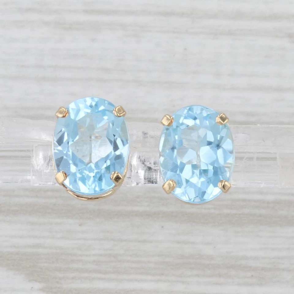 Aretes solitarios de oro amarillo de 14 k con topacio azul ovalado de 4,30 quilates Foto 2 de 4