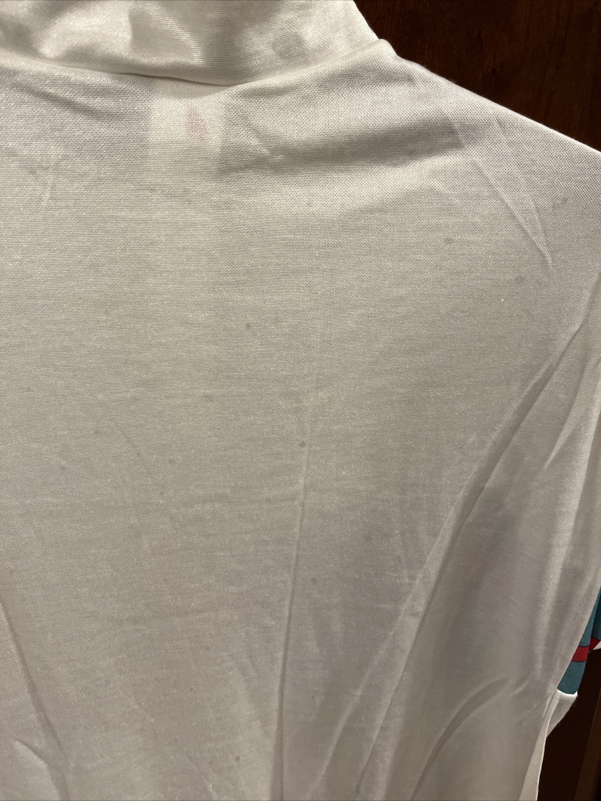 White vintage Frank Shorter sports wear cycling jersey with raised short-sleeve collar and small red and blue arm logo.
