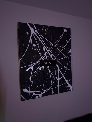 One of one painting. Black with white stripes. GOAT sticker in the middle 
