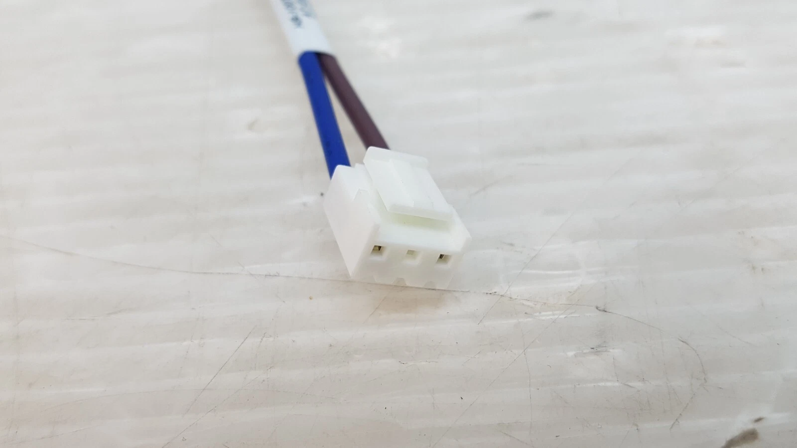 White 3-position plug housing on the brown and blue lead