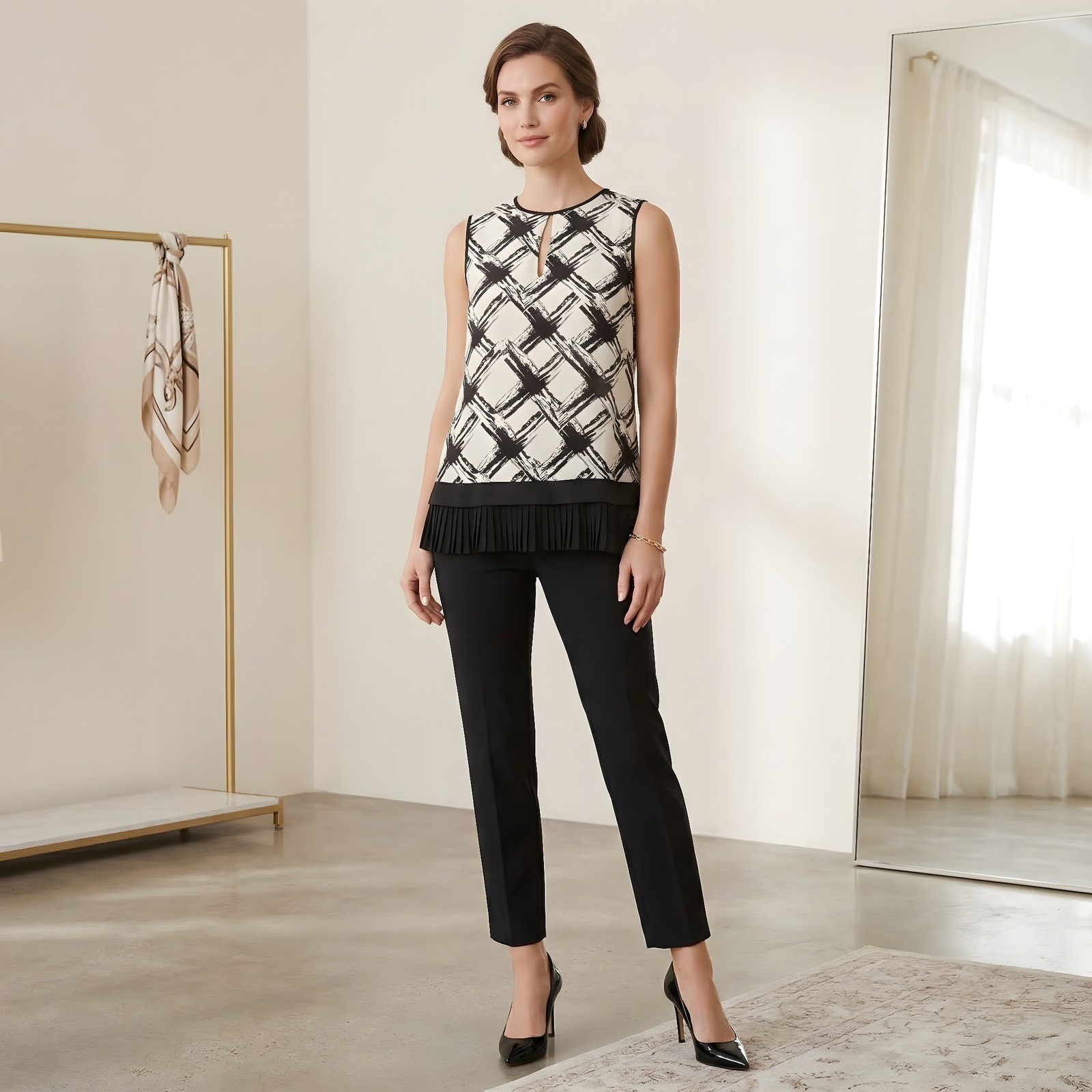 Black and ivory abstract print sleeveless silk blouse with pleated hem.